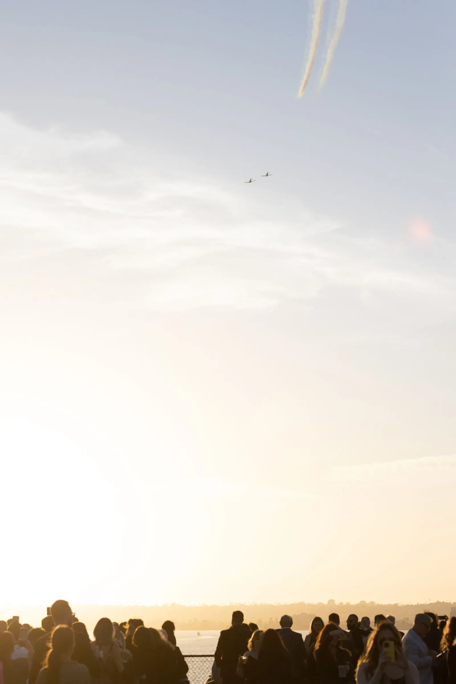 Silhouetted guests watching the sunset and planes flying overhead from an event deck, photographed by Marquee Visuals.